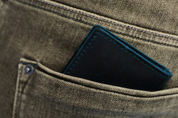 black men's wallet made from high-quality genuine leather is in the back pocket of men's jeans,