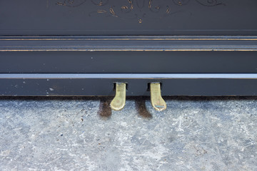 Piano pedals. Old-fashioned antique ornamental piano with carved pillars