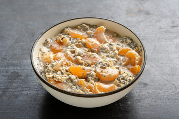 Muesli and yogurt with banana, mandarin, chia seeds and oat cereals, healthy food concept, close up