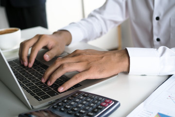 The human hand uses the keyboard by the notebook on the desk. Internet education and communication concepts