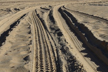 Four wheel drive tyre marks at ground level in sand background