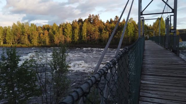 Suspension bridge on Glomma River in the forest in Hedmark county in Norway