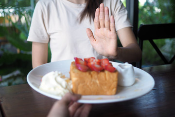 Women refuse to eat sweets for weight loss and good health.