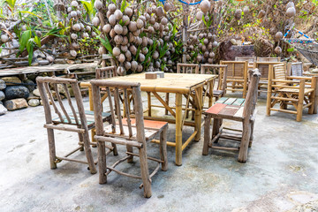 Obraz premium Wooden table and chairs in empty beach cafe next to sea. Island Koh Phangan, Thailand