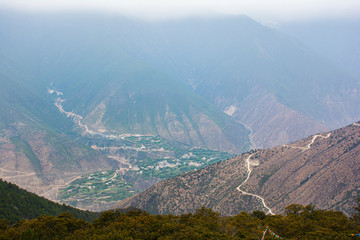 Landscape Scenery on the road between Lijiang and Shangri-La, Yunnan Province China. High Altitude Mountains, small village, Tibetan culture. Bright Blue Sky, natural Chinese landscape. China Travel