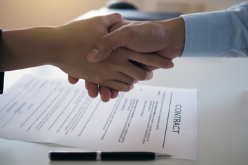 Two businessmen join hands to sign a contract. Joint venture to do business together