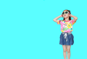Cute little Asian kid girl wearing a flowers summer dress and sunglasses isolated on cyan background. Summer and fashion concept.