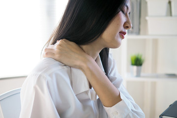 Asian women have neck and shoulder pain from sitting for a long time.