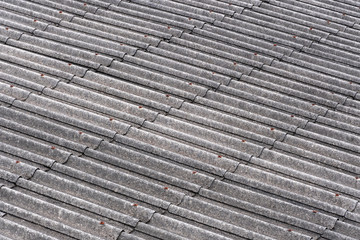 Pieces of old slate roofs covered with mold in the background. Abstract gray background with wavy texture