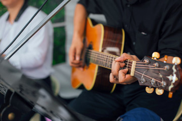 Obraz premium A Men's hand playing guitar with friends during the live performance on stage. Focus selection