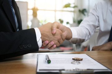 Businessmen handshake to invest and share profits in building and residential projects. Have a contract document that has legal effect