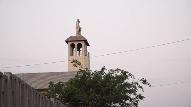 Church steeple and statue during sunset in La Molina, Lima, Peru NO MOVEMENT SHOT