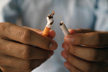 Hand breaking cigarettes The concept of smoking causes lung cancer. Just say no