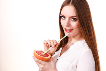 Woman holds grapefruit drinking juice from fruit