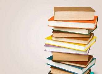 Collection of old books vertical stack on beige background