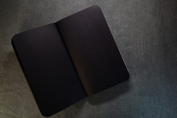 Top view of closed black cover notebook on gray background