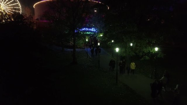 Aerial shot of people walking home from Linnanmäki, Finland Six flags in the evening by night during light carneval