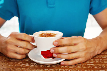 Men's hands and coffee breakfast at the wooden table