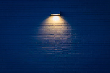 Single light illuminating a brick wall