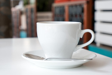 White mug closeup on a cafe background. Place for inscription. A different drink in the cup: coffee or tea for breakfast.