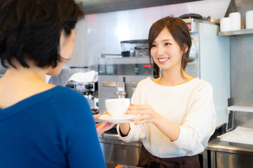 Obraz premium カフェでアルバイトする女の子