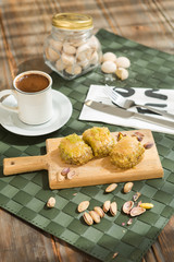 Traditional turkish and arabic dessert baklava with walnuts and pistachios Homemade  baklava on wooden plate and turkish cofffe served at bayram