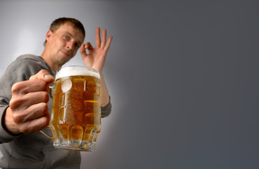 The guy offers and praises a mug of light beer