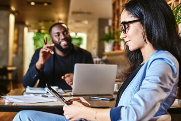Your work environment should be a friendly one. Serious woman listening to her colleague during lunch in cafe