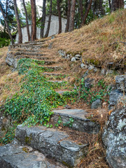 Ancient stone steps up the slope to the building of a chapel in Greece