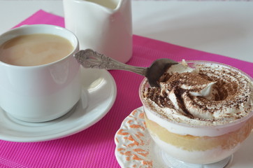 coffee with whipped cream and chocolate for breakfast. gourmet breakfast, coffee with milk, milk jug, tasty cake with whipped cream, sprinkled with chocolate or cinnamon on a raspberry background