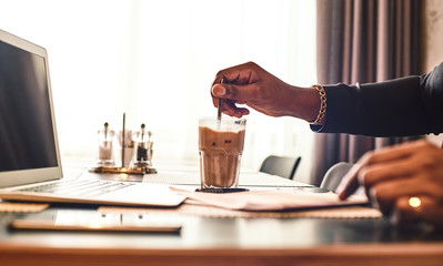 African american businessman is working, using his laptop while resting in the cafe