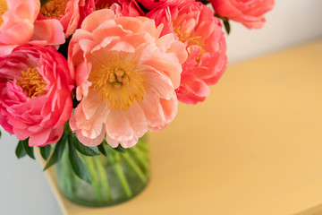 Coral peonies in a glass vase on wooden table.. Beautiful peony flower for catalog or online store. Floral shop concept . Beautiful fresh cut bouquet. Flowers delivery. Copy space