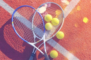 Tennis game. Tennis balls and rackets on  background.