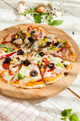 home made gourmet thin tortilla pizza on wooden plate and wood table gourmet food