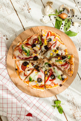 home made gourmet thin tortilla pizza on wooden plate and wood table gourmet food