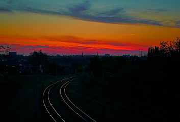 Railroad leaving into the distance on a background of red sunset
