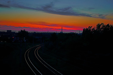 Railroad leaving into the distance on a background of red sunset