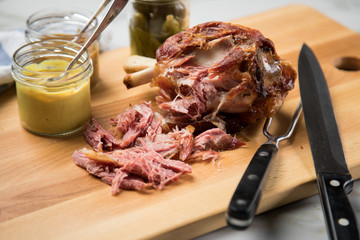 Gegrilltes Schweinefleisch Haxen Fleisch auf Holzbrett mit Cornichons, süßen und mittelscharfen...