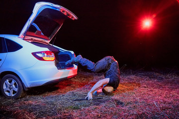 Guy jumpint from the trunk of a car in a night time. Photoshoot about gangster life in Russia