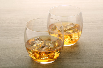 Two glasses with whiskey with ice cubes	