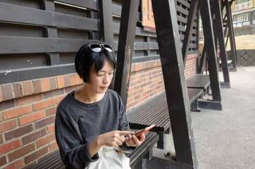 woman sit on a chair and using a smart phone