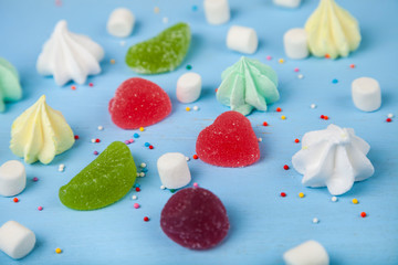 Meringue,marmalade and marshmallow on a blue background.