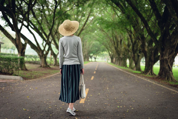 woman take a walk on the way under the trees