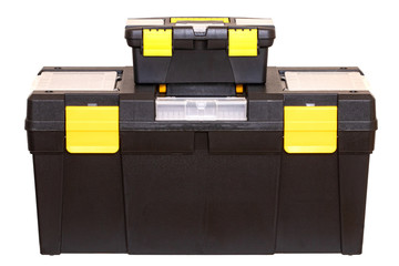 Tool boxes isolated. Closeup of a big black plastic tool kit box with yellow handle and clasp and a little black plastic tool kit box with nails, screws and dowels isolated on a white background.