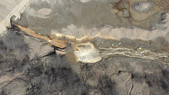 Mining waste  and pyrite on river coast 4K drone video