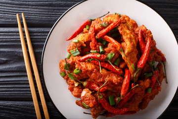 Chinese food chicken in Schezwan sauce close-up on a plate. horizontal top view