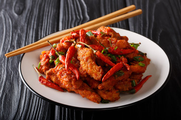 Traditional spicy szechuan chicken in Schezwan sauce close-up on a plate. horizontal