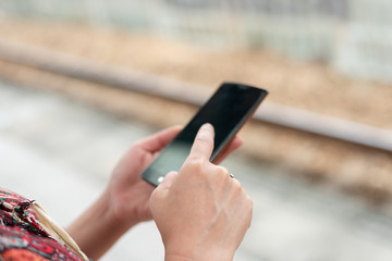 mature traveling woman waiting and using a cellphone