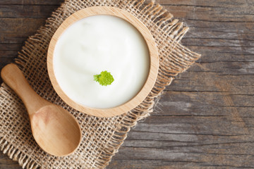top view of natural greek yogurt in cup on old wooden table background. Yogurt is delicious tasty and healthy