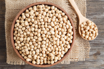 Soybeans in a wooden cup on the old wood table,top view.